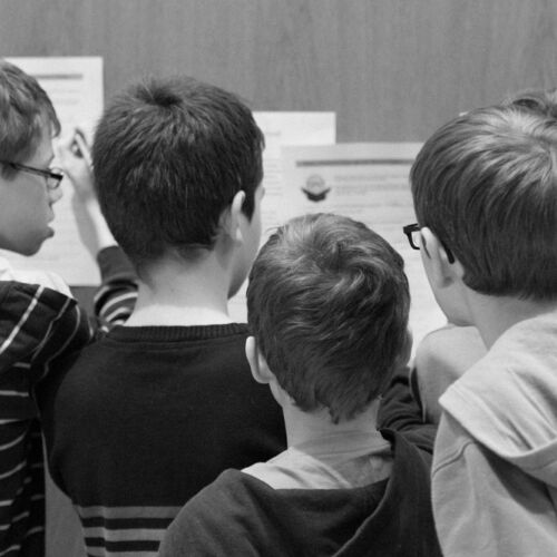 Drei Kassen der Bibliothek Sproochbrugg beim Zuhören und Rätsellösen.