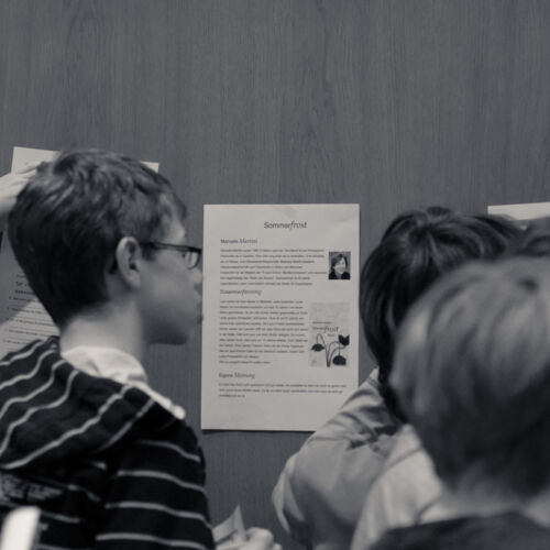 Drei Kassen der Bibliothek Sproochbrugg beim Zuhören und Rätsellösen.