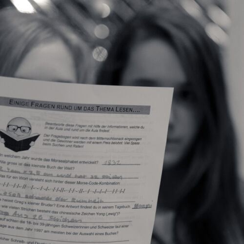 Drei Kassen der Bibliothek Sproochbrugg beim Zuhören und Rätsellösen.